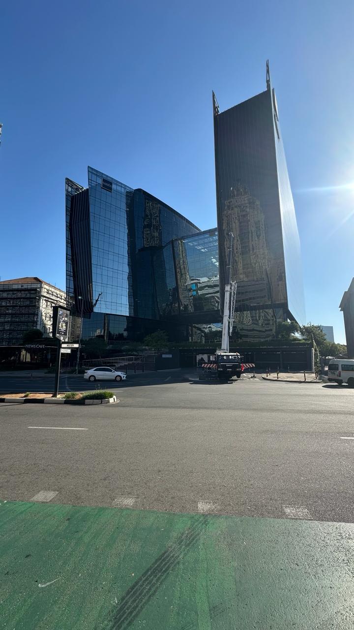 High-rise office building with a crane positioned at street level