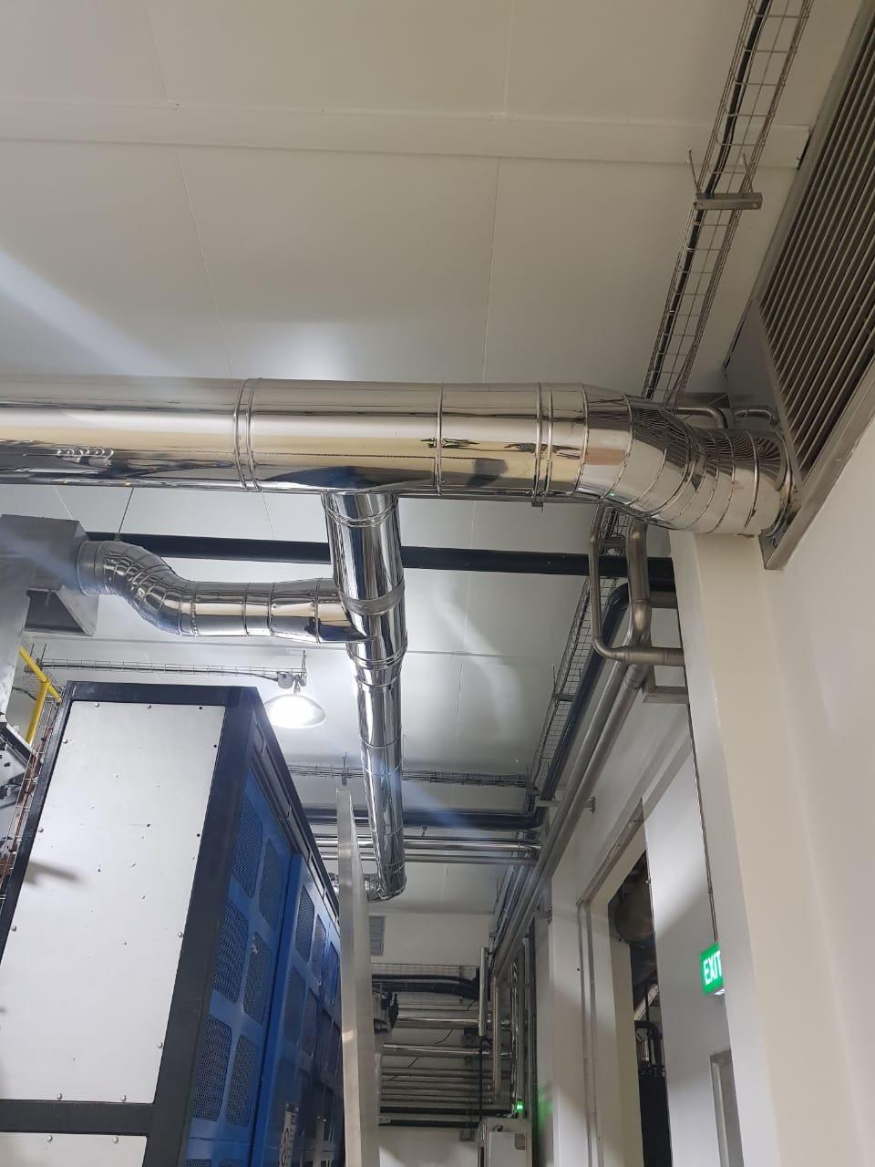 Spiral ducting routed through a plant room next to a chiller